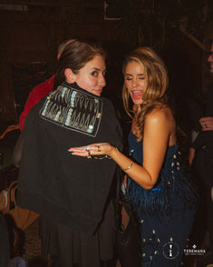 Two women at an event, one smiling at camera