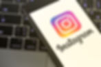 Instagram app open in a mobile which is placed on a laptop