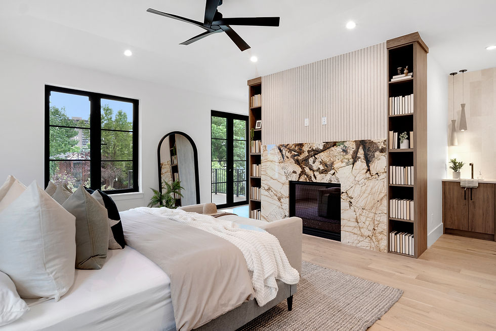 Bright modern bedroom with neutral bedding, black-framed windows, a statement stone fireplace, built-in wood shelving, and light hardwood floors.