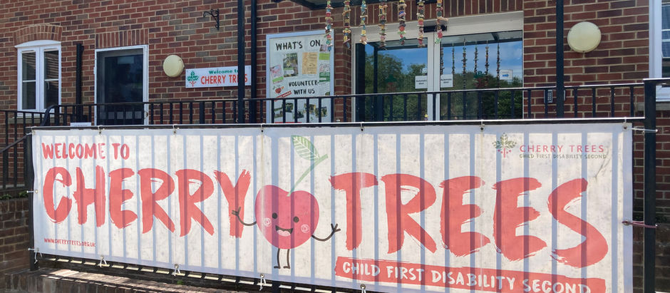 Photo of Cherry Trees respite care home, with a banner saying 'Welcome to Cherry Trees: child first, disability second' in red writing on a white background.