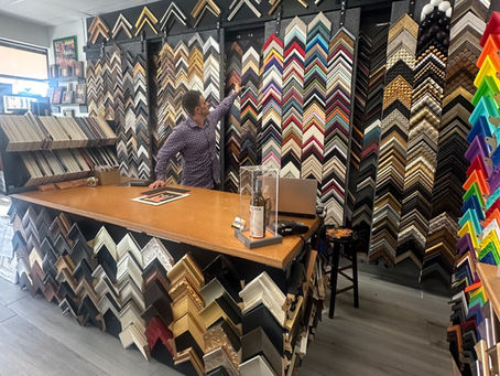 A framer working with a customer at a design table