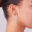 Thumbnail: Woman wearing a dazzling long silver drop earring with clear stones.