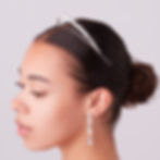 Thumbnail: Woman wearing delicate silver headband and long sparkling drop earrings.