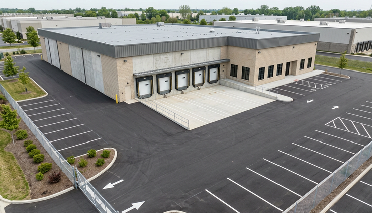 High-angle view of a vacant industrial building with a clean loading area.