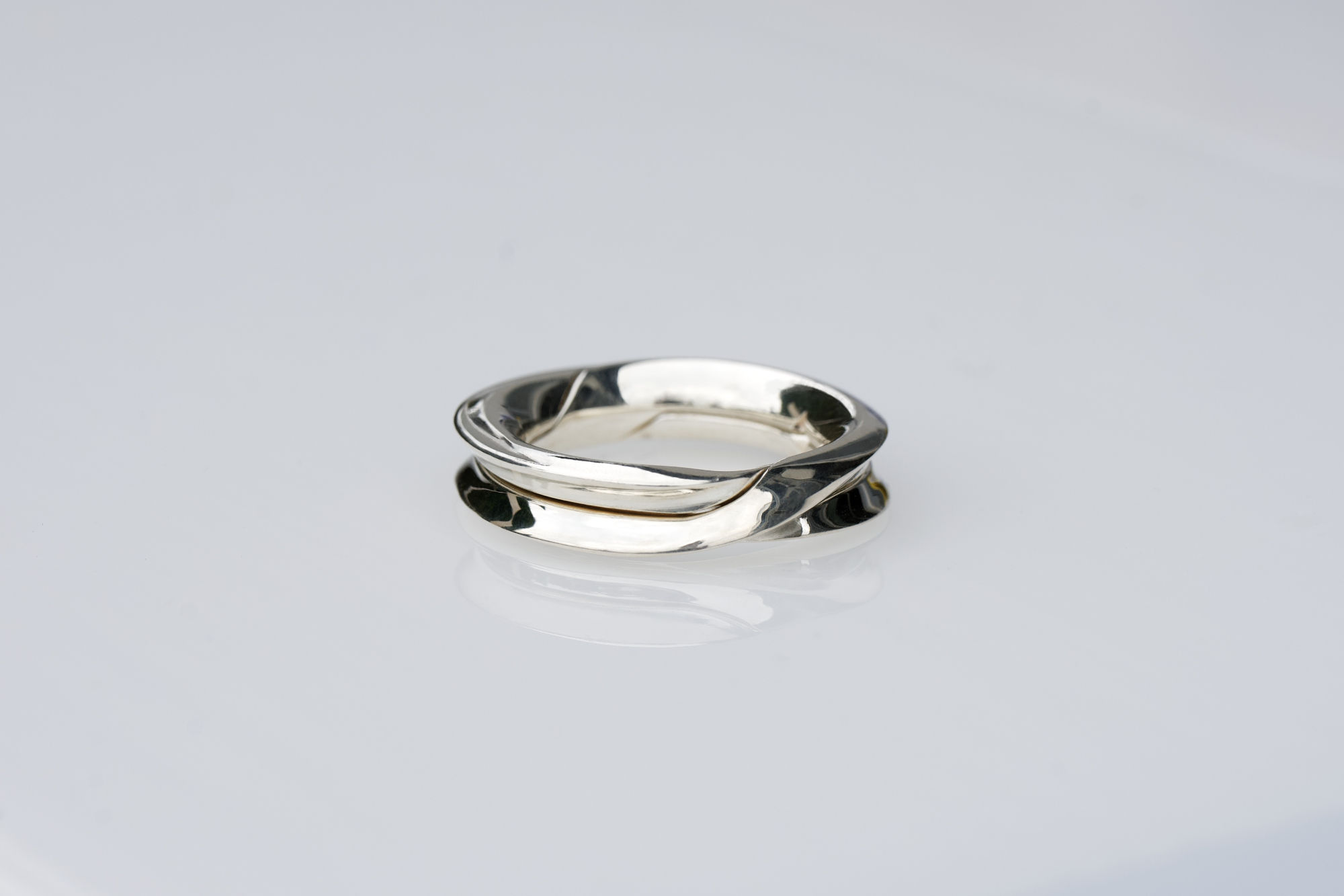 Ring Rugam DA/S in Silber mit polierter Oberfläche liegend.