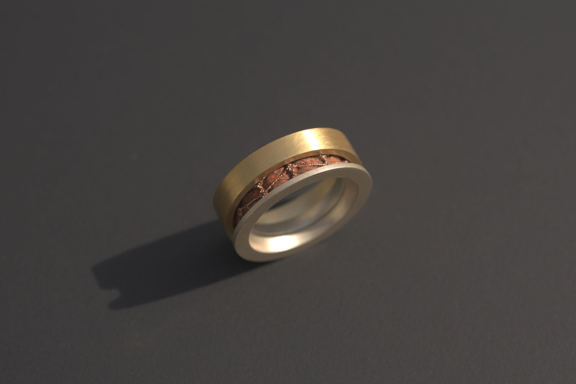 Ring Cassetto konisch mit eisen-brauner Patina, aufrecht stehend, asymetrisch auseinander geschoben