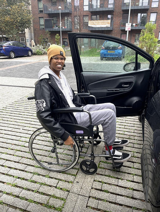 Client Dominique in a wheelchair post-operation
