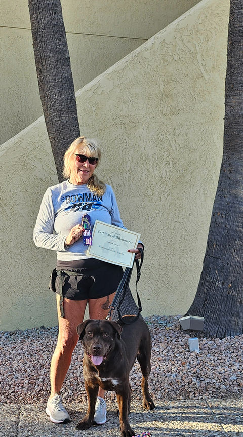 Woman with chocolate lab mix holding graduation certificate at 6 Paws Training Camp in Tucson, AZ, showcasing successful dog training and proud pet-owner achievement - 6 Paws Training Camp Tucson AZ