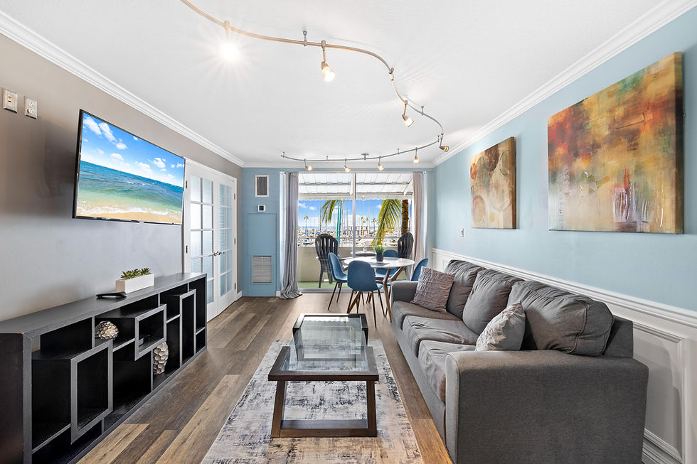 Modern living room featuring a dining or relaxing area by the balcony, showcasing marina views and abundant natural light, all set on chic wood-like flooring