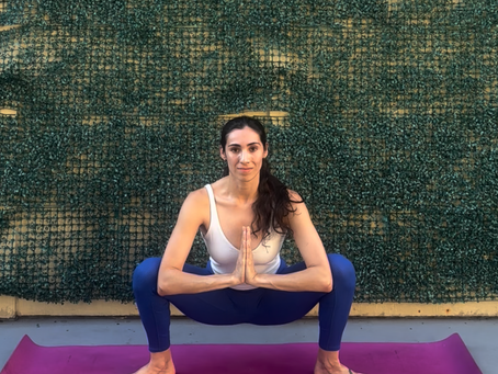 Elisha in Malasana (Garland Pose), feet wide, hips low, hands at heart center, elbows pressing knees open
