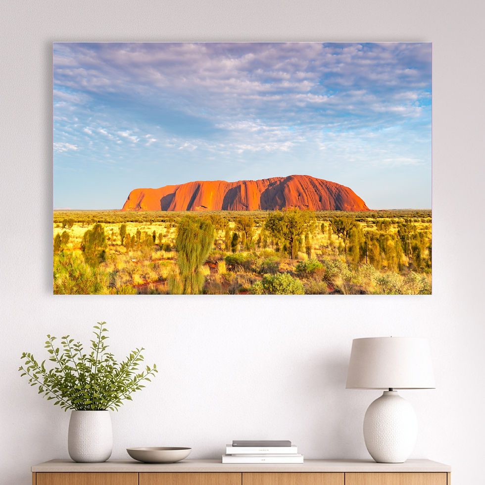 Metallic glass print hanging on wall showing Uluru at sunrise with desert landscape