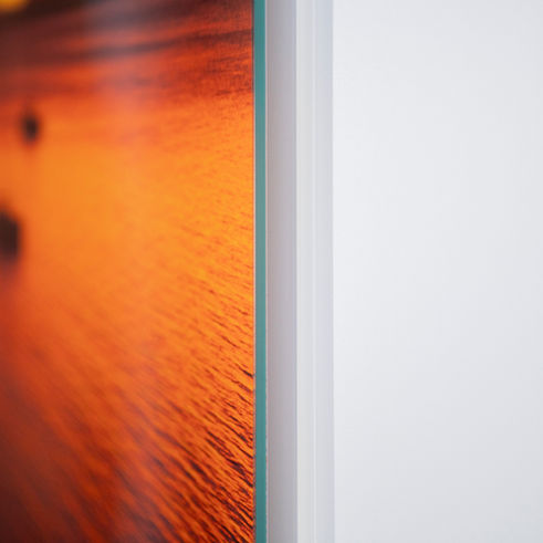 Macro shot of the glass mount’s polished edge and mounted photographic print with rich orange tones.