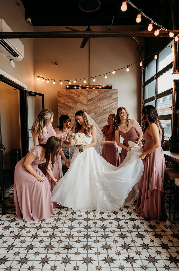 Bridesmaids helping a bride get ready for her wedding day.
