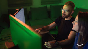 2 people working on computer with NVIDIA green
