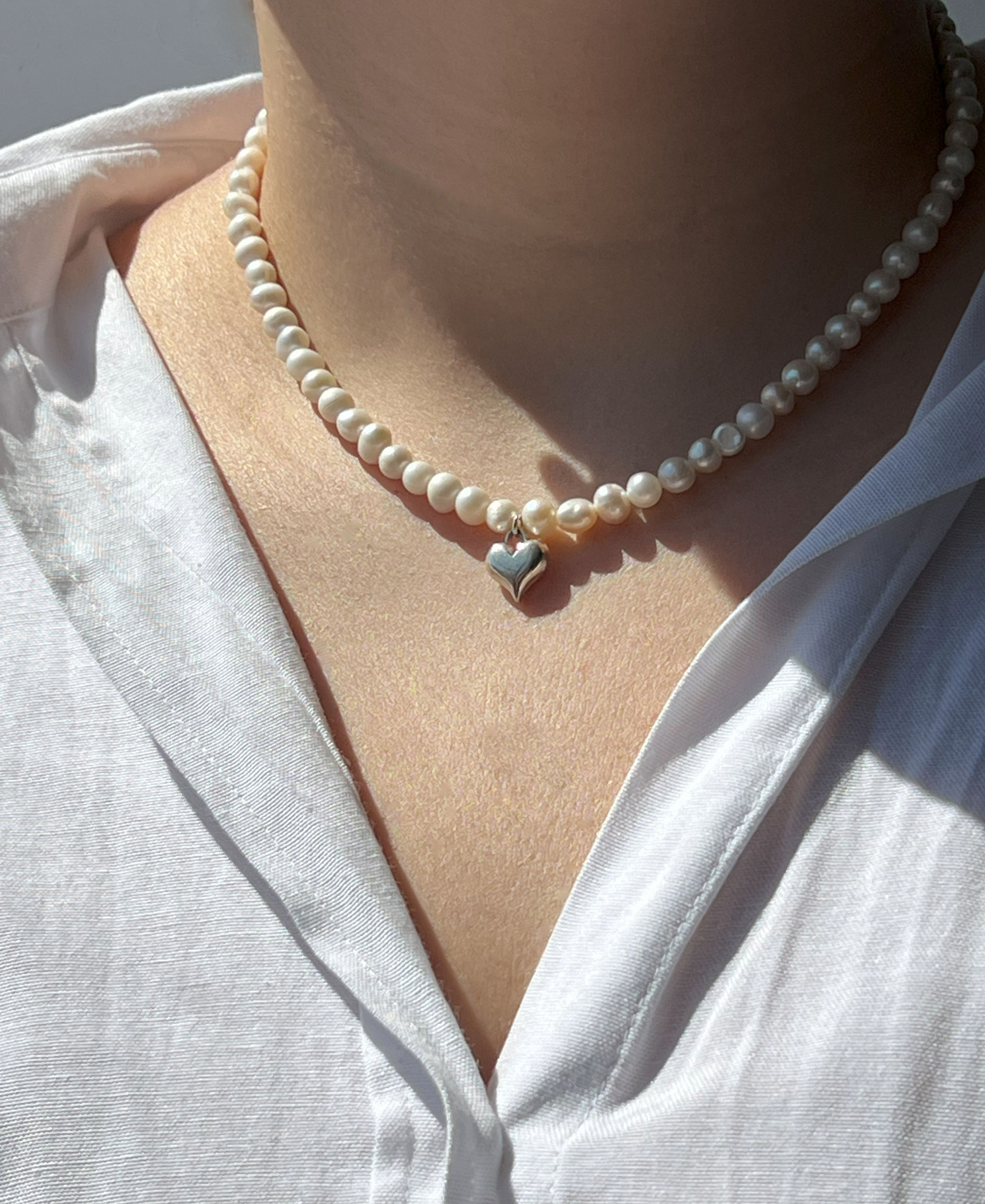 שרשרת פנינים עם תליון לב, Pearl Heart, על חולצה לבנה, Handmade Bliss