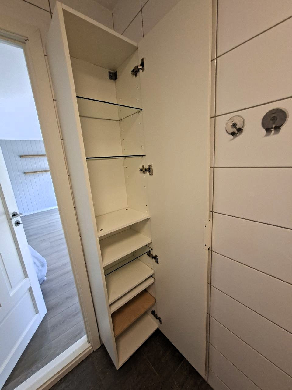 Empty wall-mounted shelves in a small room corner.