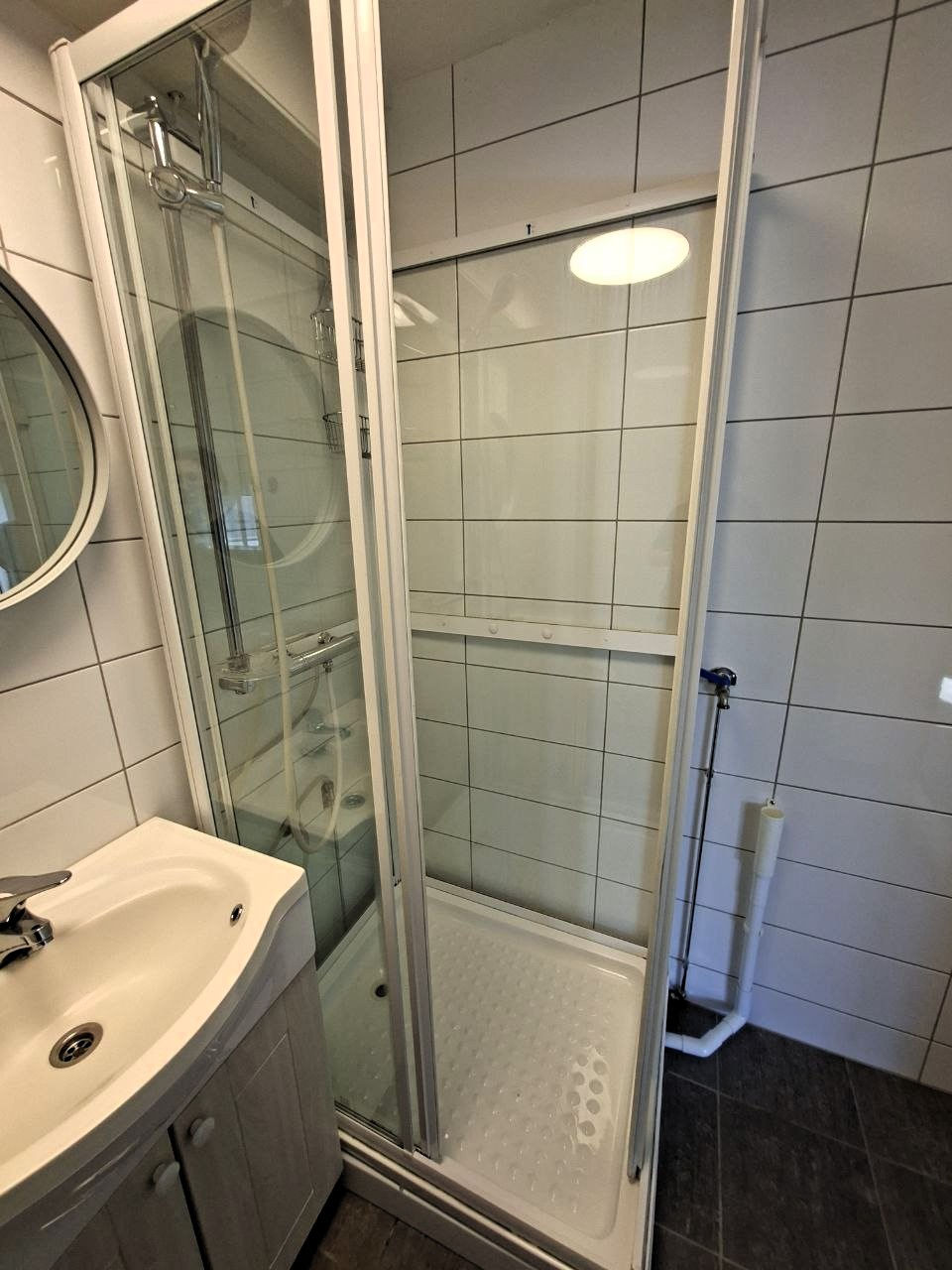 Small bathroom with shower and sink.
