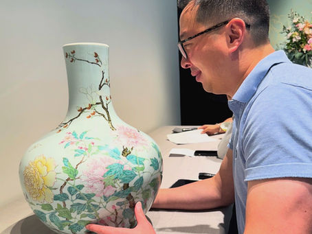 Anthony Wu examining a rare Chinese famille rose porcelain tianqiuping vase with Yongzheng mark and period, and decorated with peony, magnolia, and peach blossom, that sold for USD 2.6 million at Sotheby's New York in September 2025