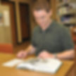 Stuart Lutz examines a document. He says, "Working with documents is far more interesting than reading about history in graduate school."