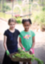 Ella Prager and Camille Dazulma with radish greens and spinach. Photo by Julia Maloof Verderosa.