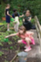 Monika Hannemann fills watering cans so children can water their plants. Photo by Julia Maloof Verderosa.