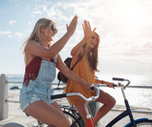 stop drinking fast. mindset transformation. two happy carefree girls on bikes 