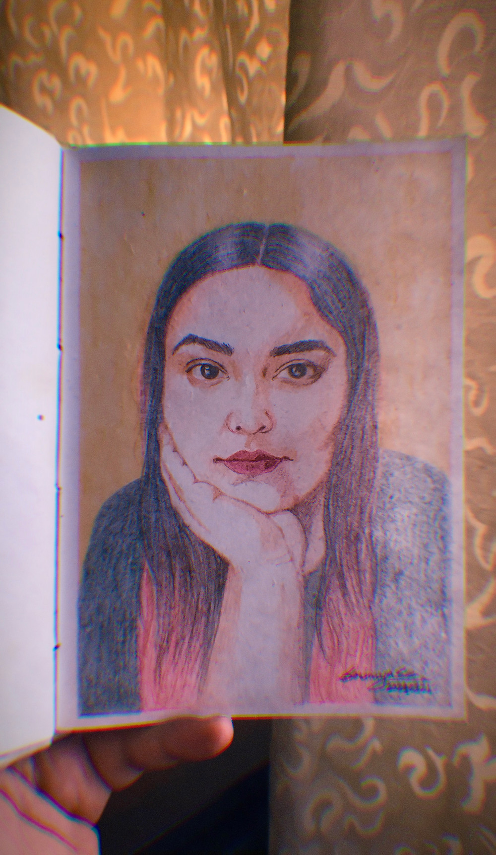 a picture of a page from a sketch book. the sketch is self portrait of the author/artist made with pencil colours.