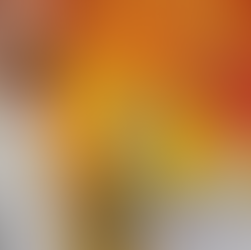 Child using hands to move orange paint around on top of the paint waterfall which is a large canvas over a wall.