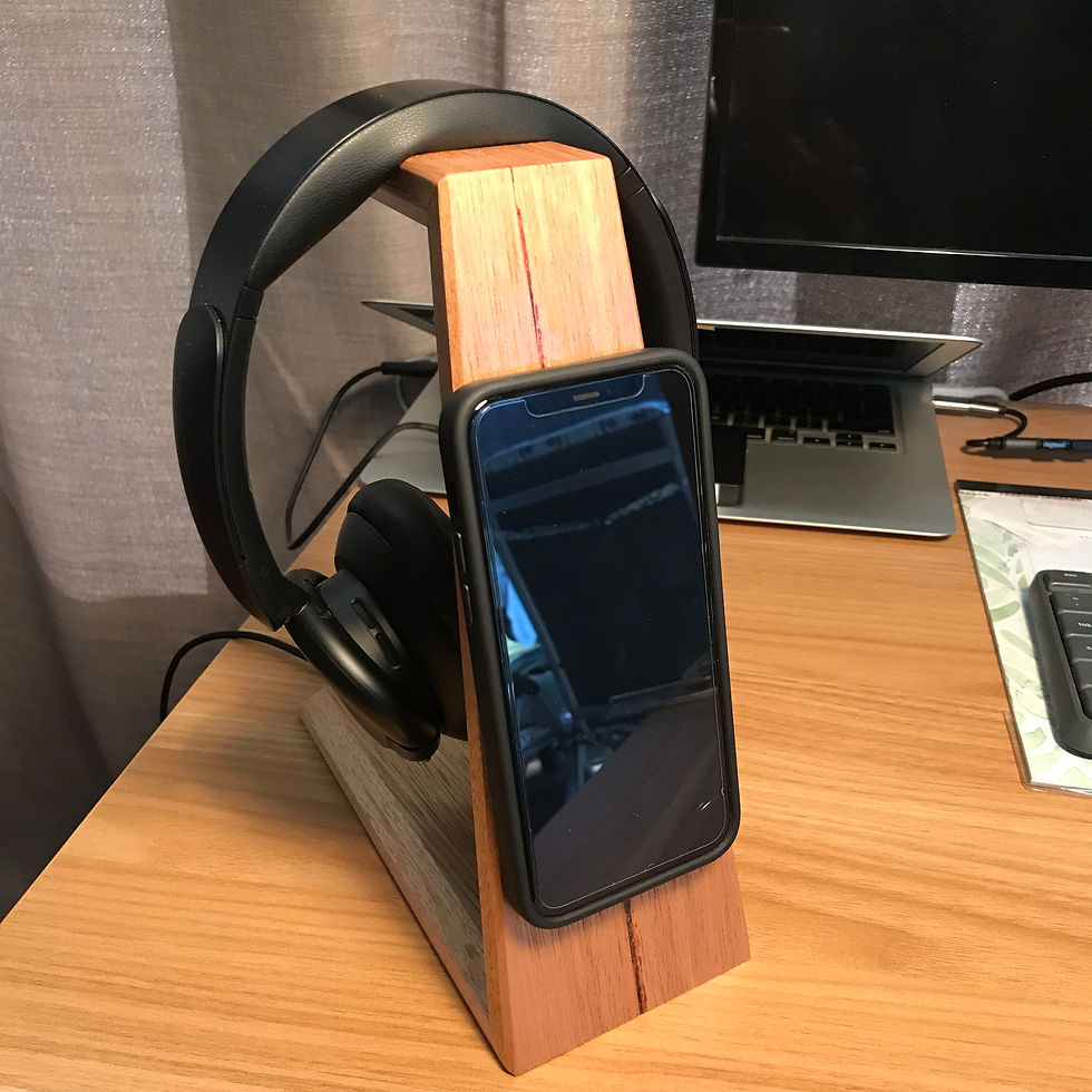 2-in-1 Headphone Stand with Wireless Phone Charger on desk, with headphones hanging on rest, phone held to magnetic charger