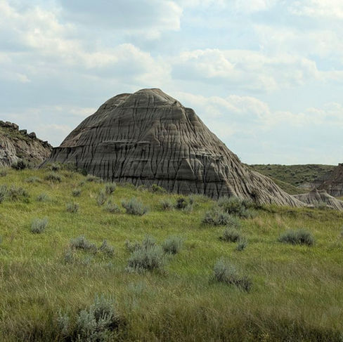 a hill made of unique sandstone rock formation surrounded by grass