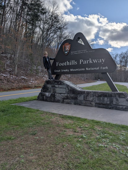 Kid standing on the foothills parkway sign