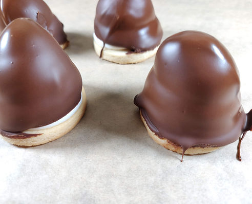 Vegan krembo treats with fluffy cream on a biscuit base, coated in smooth chocolate.