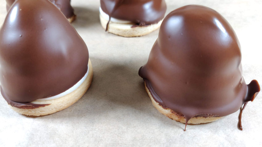 Vegan krembo treats with fluffy cream on a biscuit base, coated in smooth chocolate.