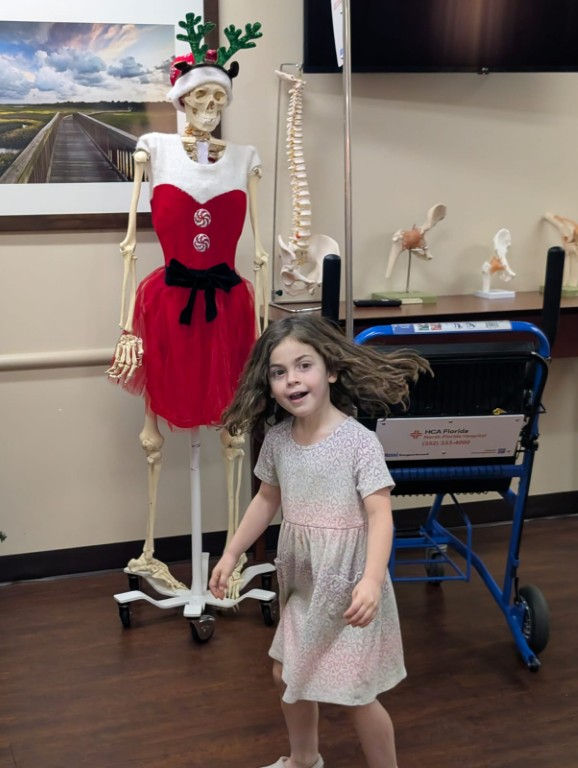 My Lenni, making friends with a dressy skeleton when visiting me at the hospital during our interrupted trip