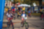 Children and adults cycling together at a community event.