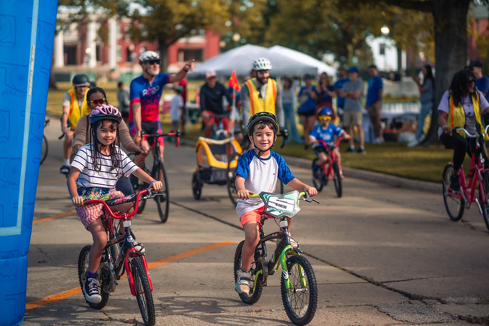 Children and adults cycling together at a community event.