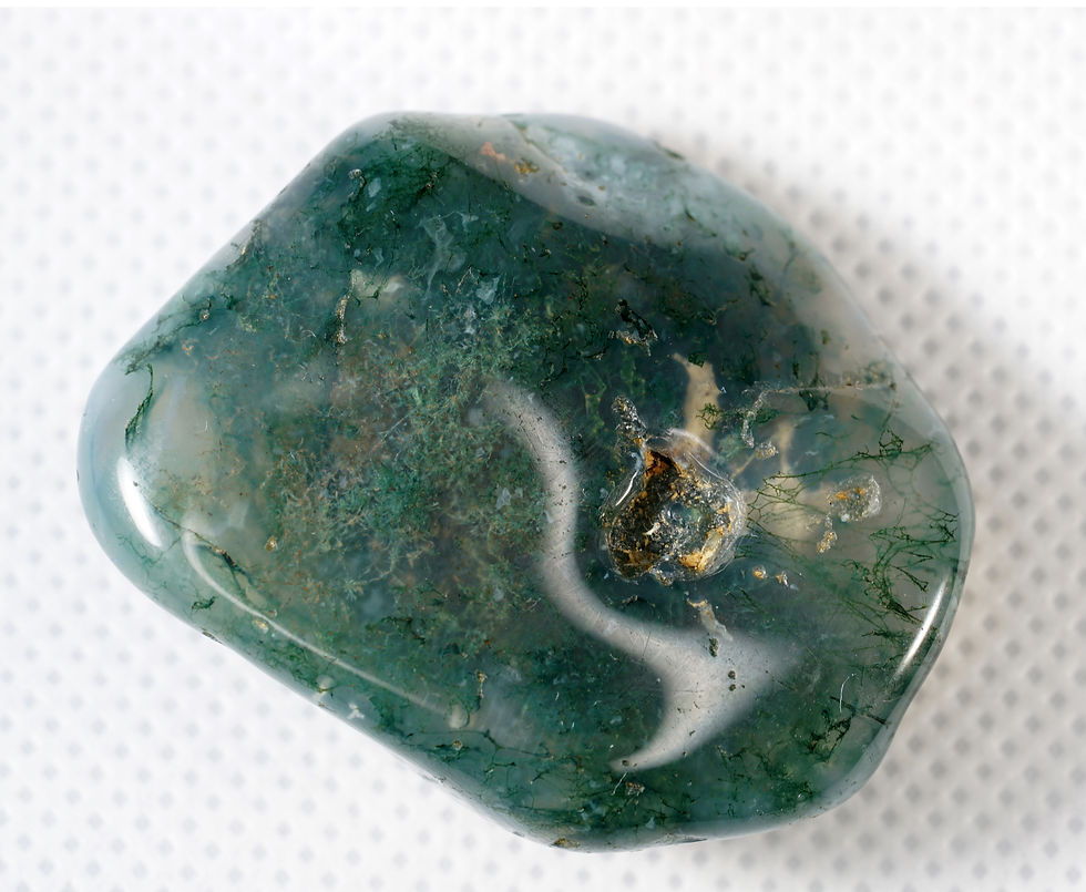 Close-up of an amber-colored gemstone with smooth, glossy surface and intricate patterns, set against a plain white background.