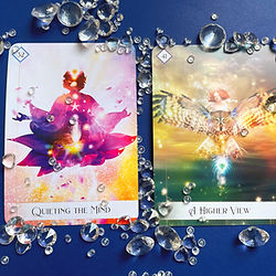 Two oracle cards drawn during a reading, surrounded by crystals