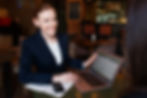 A professional holding a laptop, symbolizing the balance of influencing both supervisors and team members in assistant leadership.