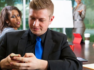 Employees seated around a conference table during a workplace meeting, illustrating employee silence and communication challenges within an organization.