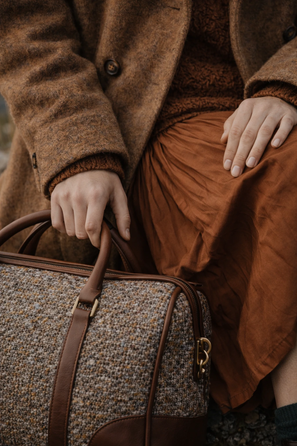 plano detalle de unas manos sujetando un bolso de color marrón