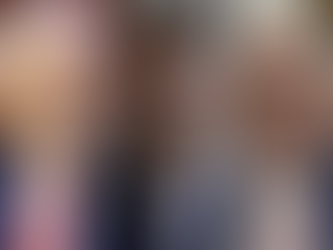 Três homens de meia-idade em close com expressões sérias. Todos usam ternos escuros e gravatas coloridas. Fundo neutro.