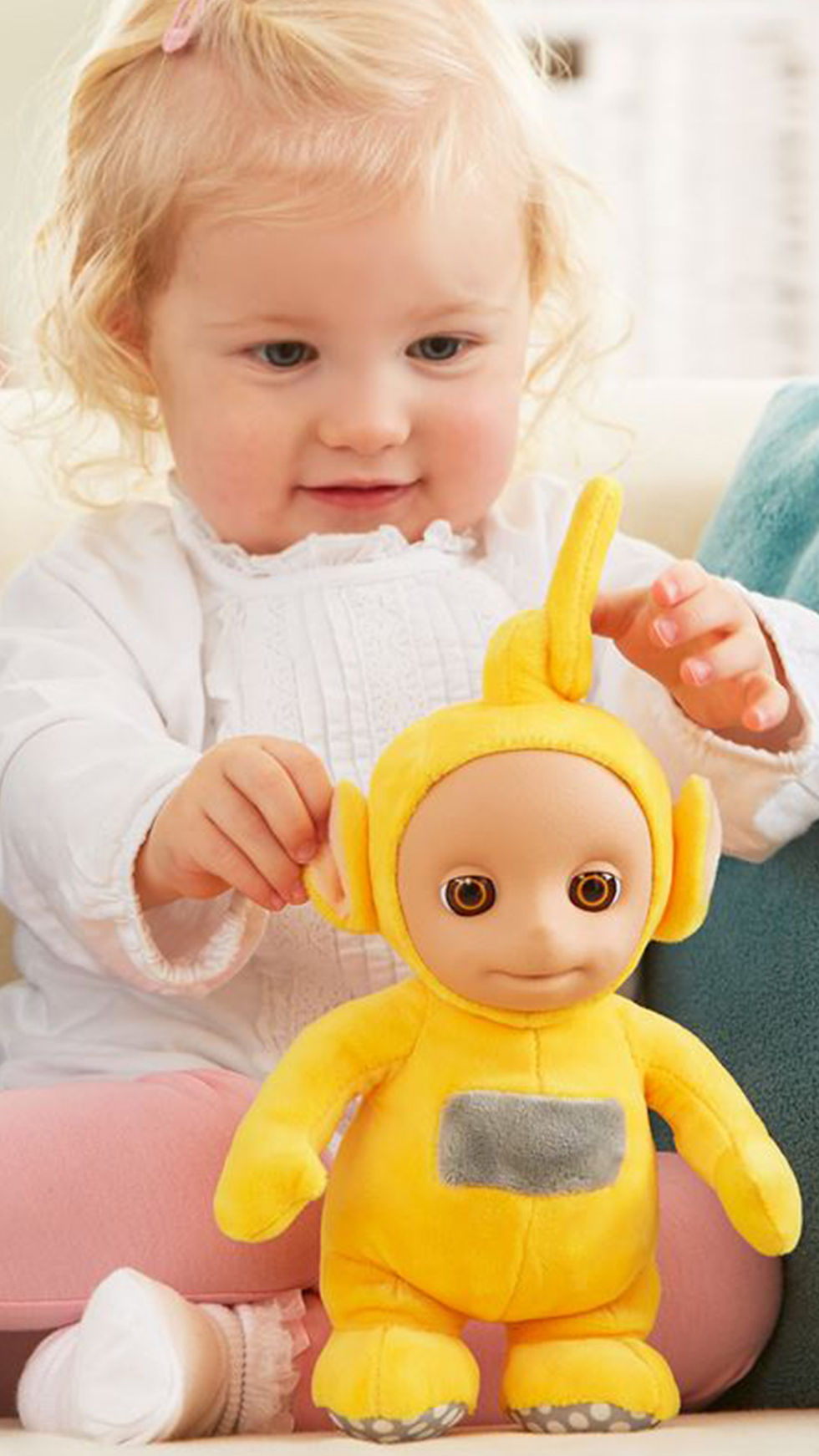 young girl holds yellow plush toy