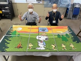 doctors sit behind a painted mural