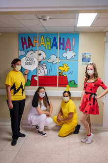 children in fancy dress stand in front of a painted mural