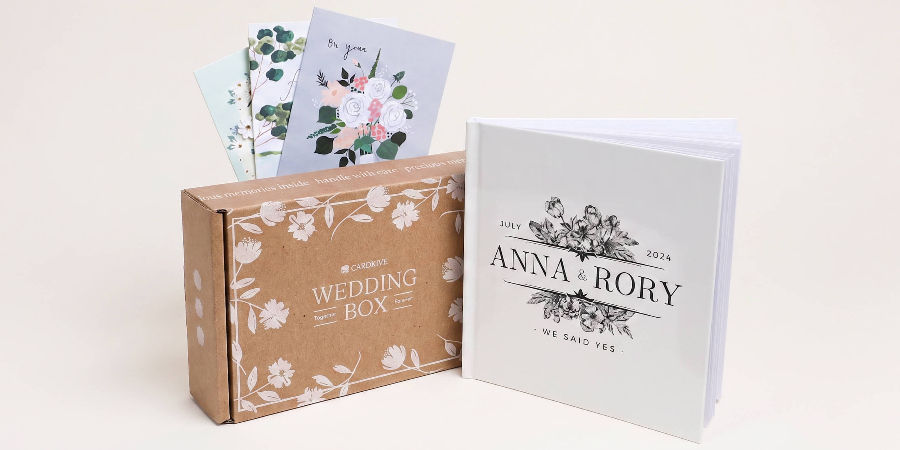 Cardkive Wedding Cards Book box with greeting cards fanned out next to the finished "We Said Yes" keepsake book