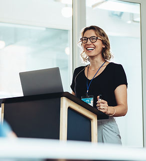 Businesswoman standing at podium with laptop giving a speech. Successful female business p
