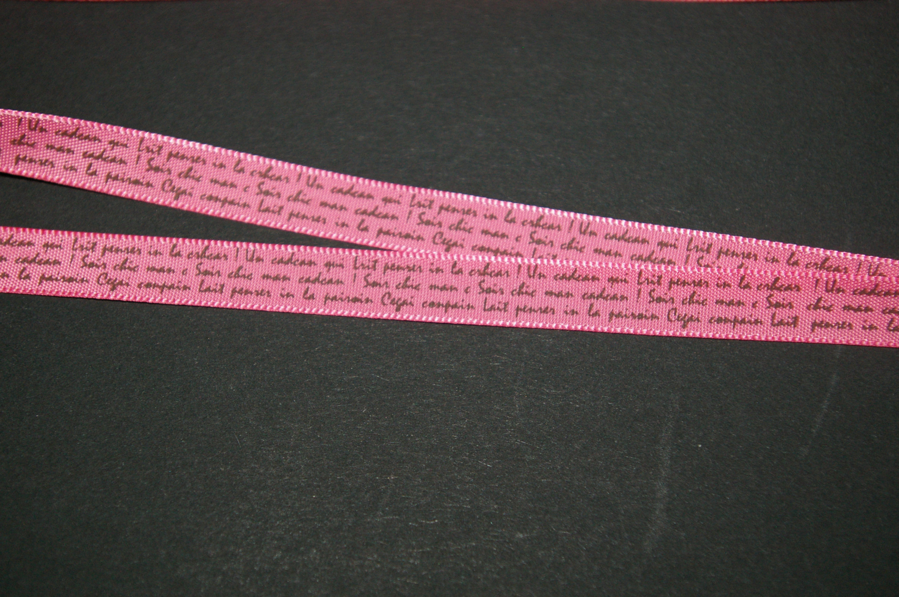 pink ribbon with black writing in 9mm sold by the meter
