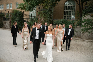 A bride and groom walking with their wedding party in the library district with a kansas city photographer