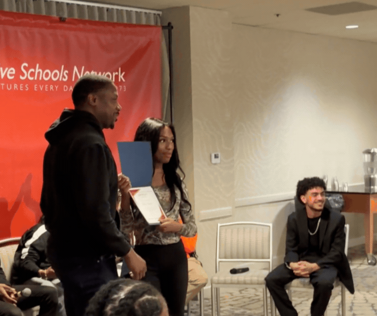 Sheri accepts a certificate of honors from Jahmal Cole of My Block, My Hood, My City after speaking on a panel about urban youth issues.